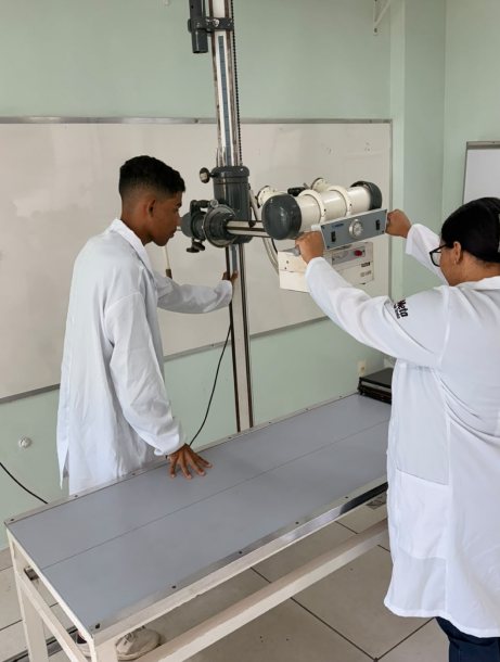 Alunos operando equipamento no laboratório de radiologia